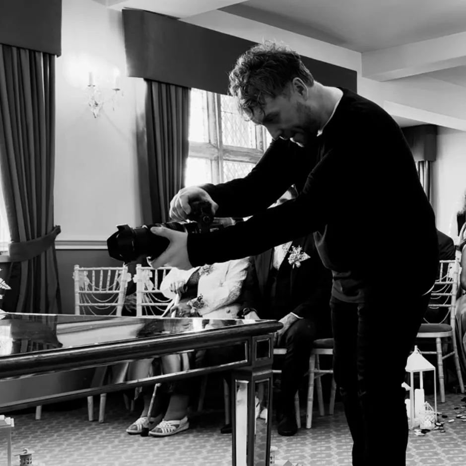 Rob crouching to frame a shot during a ceremony
