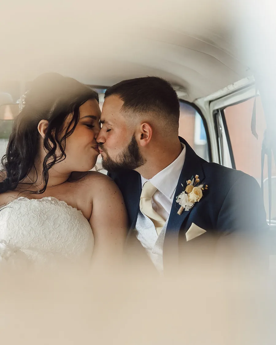 Couple sharing a kiss inside a vintage camper van