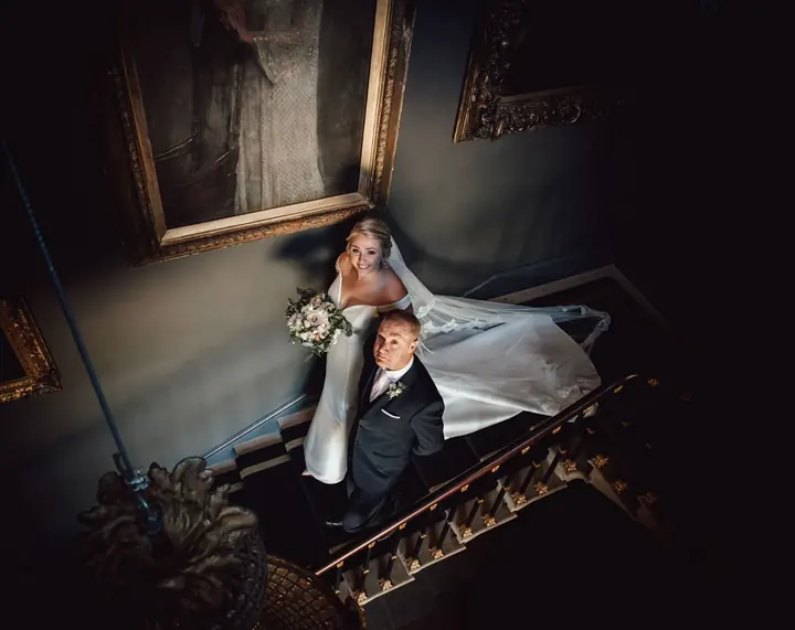 A bride and her father on the staircase, seen from above