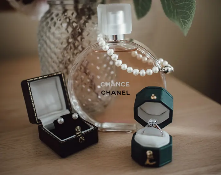 Earrings, rings and perfume laid out together
