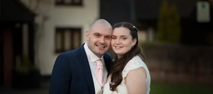 A couple smiling outside the venue in the evening