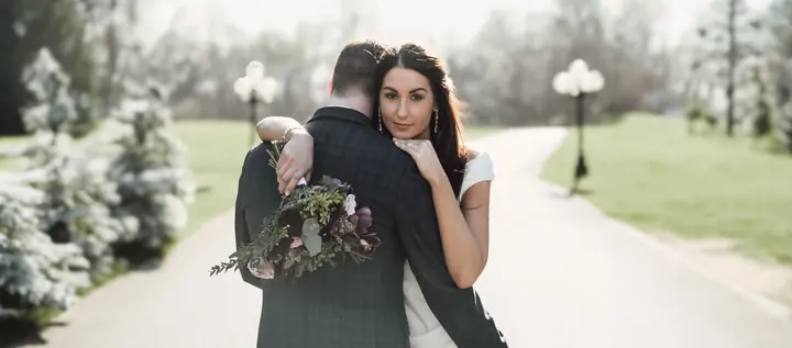 A couple embracing on a tree-lined path