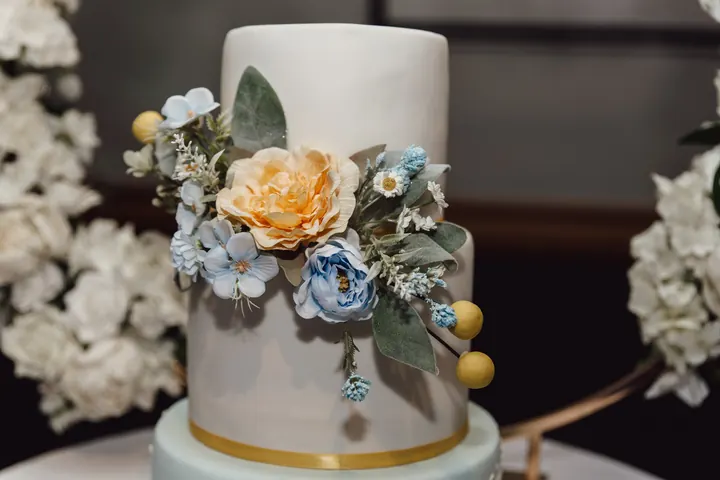 The cake decorated with yellow and blue sugar flowers