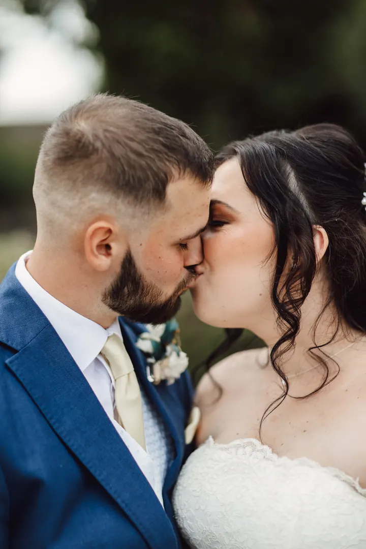 Laura and Owen kissing in the greenery
