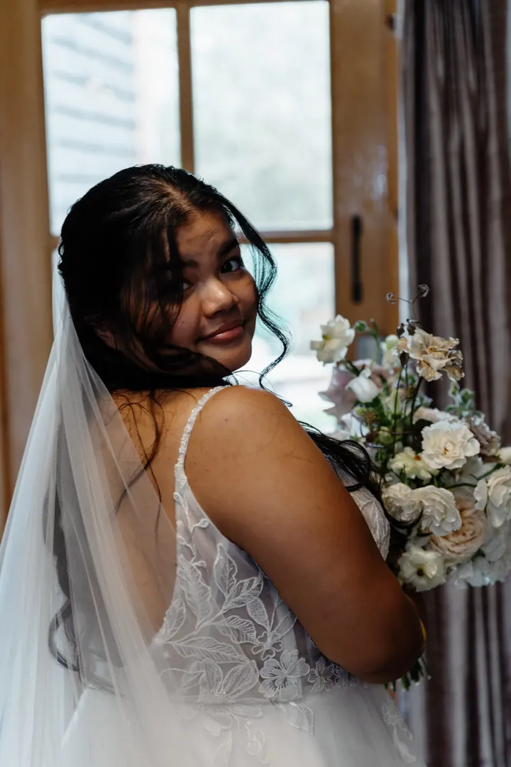 Gloria glancing over her shoulder with her bouquet