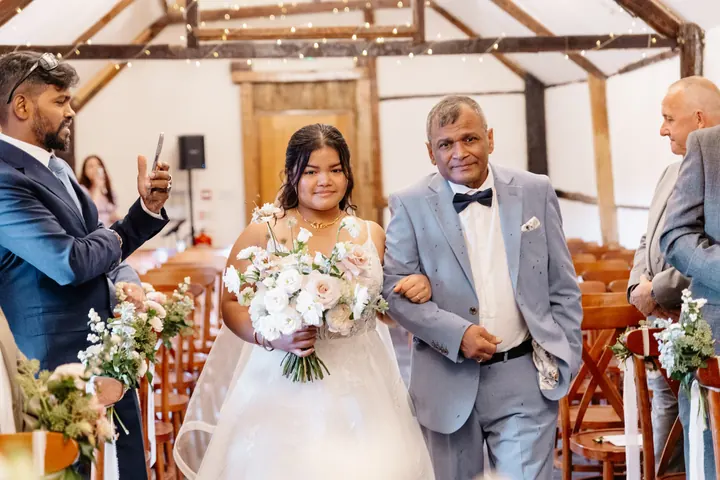 Gloria walking down the aisle with her dad