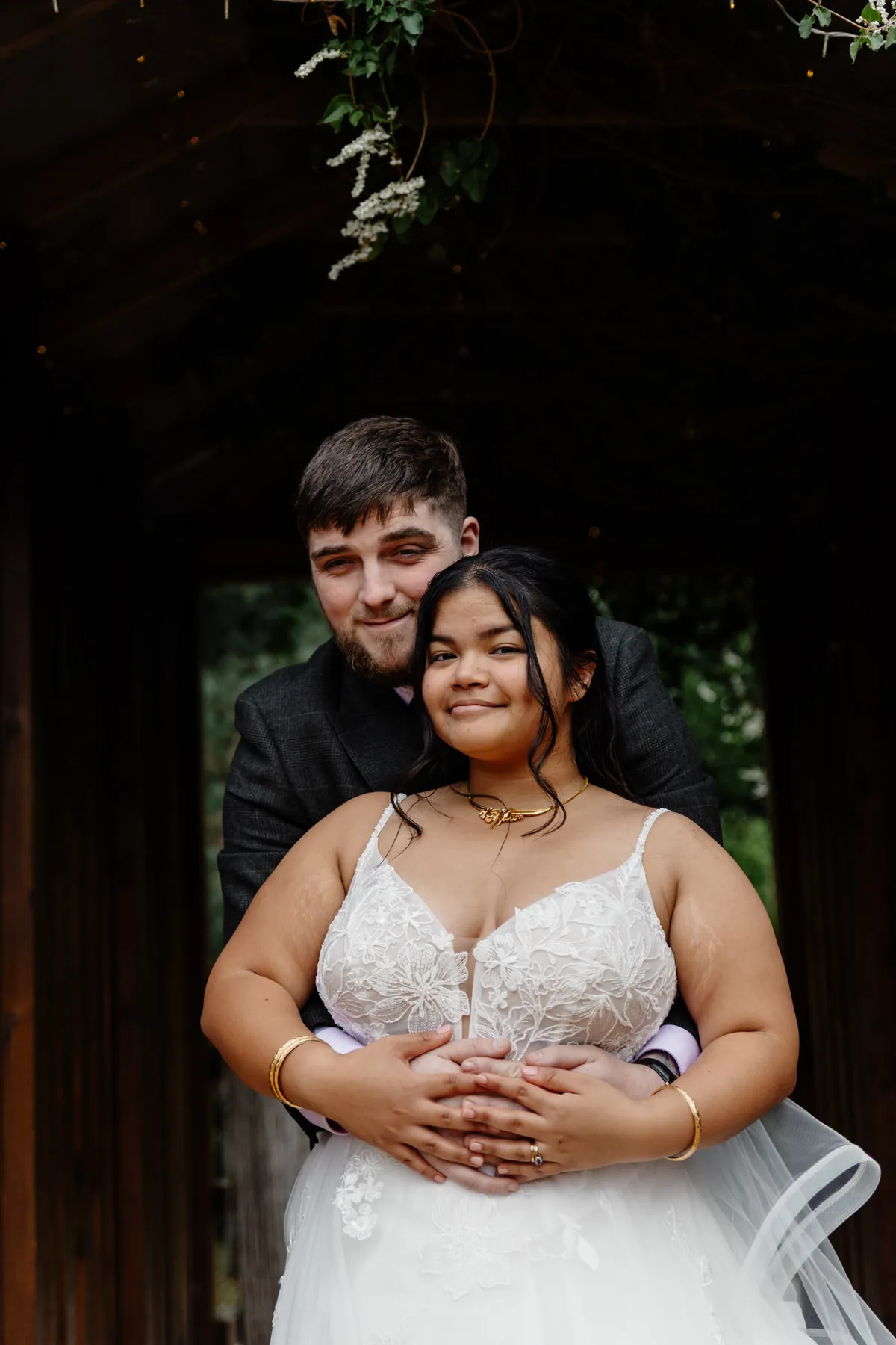 Oliver holding Gloria from behind in a wooden doorway at Coton House Farm
