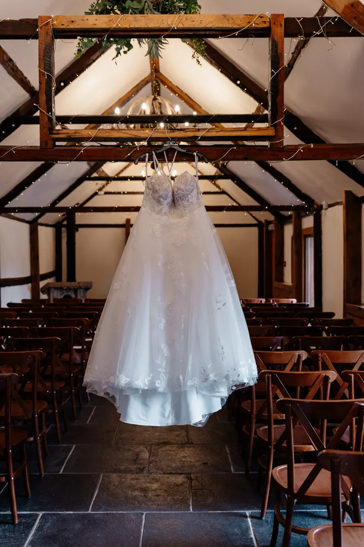 Gloria&rsquo;s wedding dress hanging in the Old Dairy Barn at Coton House Farm