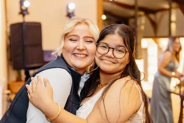 Gloria hugging a friend on the dancefloor