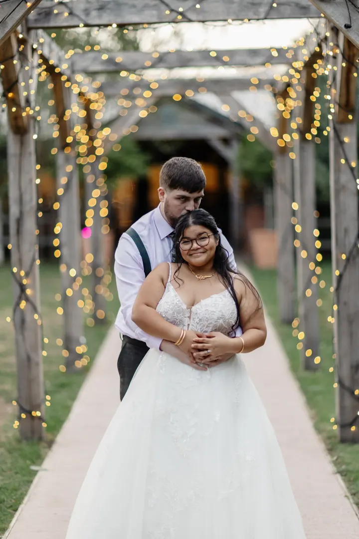 Gloria and Oliver beneath the fairy-lit pergola