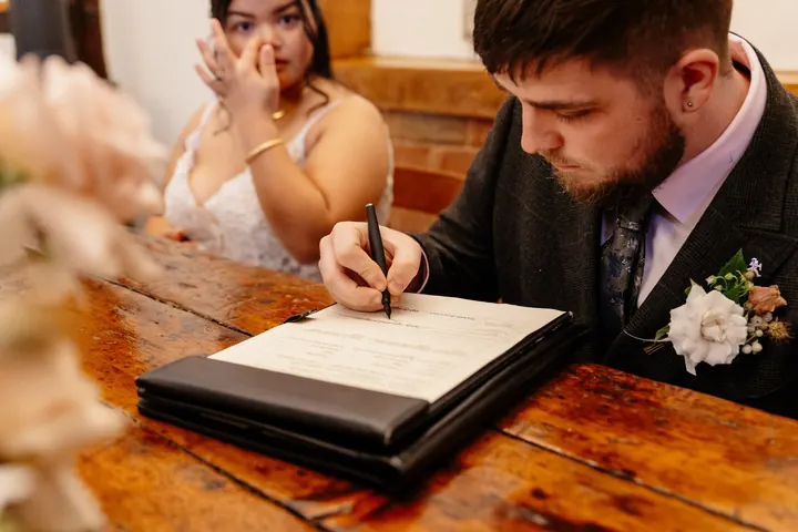 Oliver signing the register