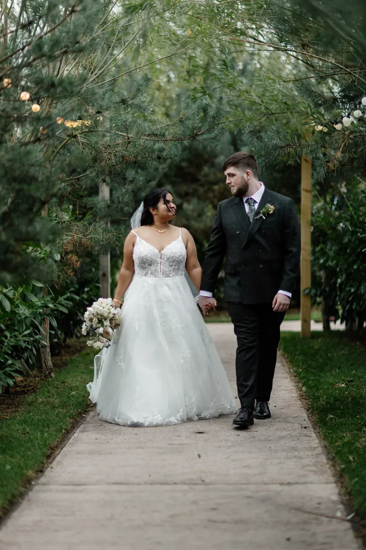 Gloria and Oliver walking hand in hand down the path
