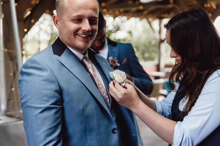 Ryan grinning as his buttonhole is pinned on