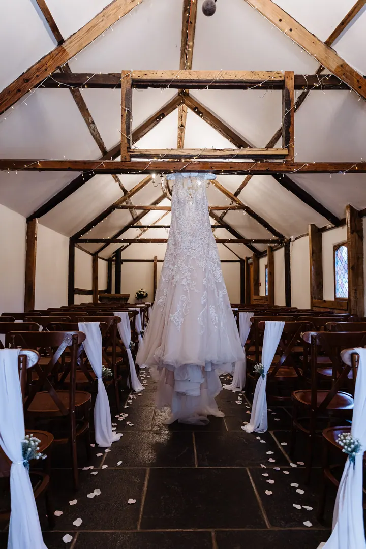 The dress hanging in the timber-framed ceremony barn