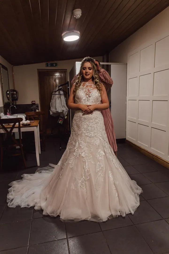 Natasha standing in her lace gown and long veil