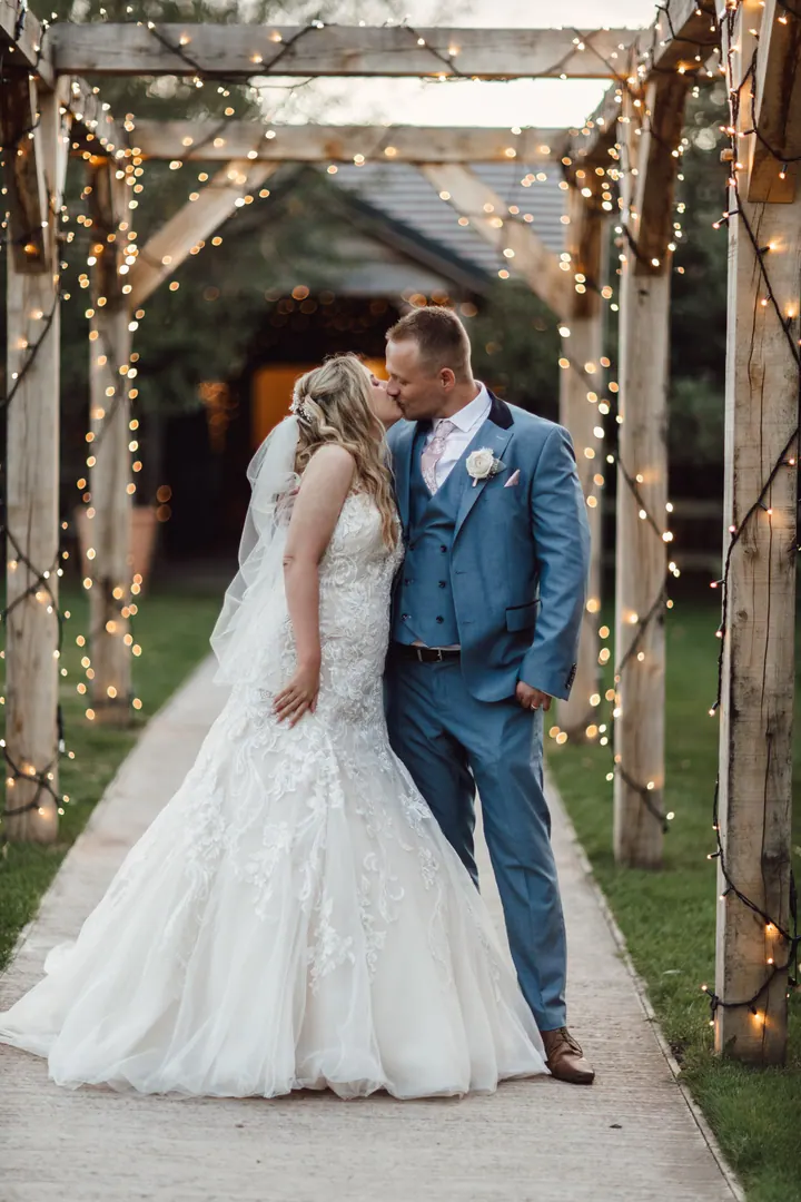 Natasha and Ryan under a fairy-lit pergola