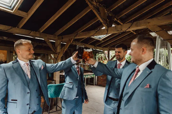 Ryan and his groomsmen raising a pint on the covered patio