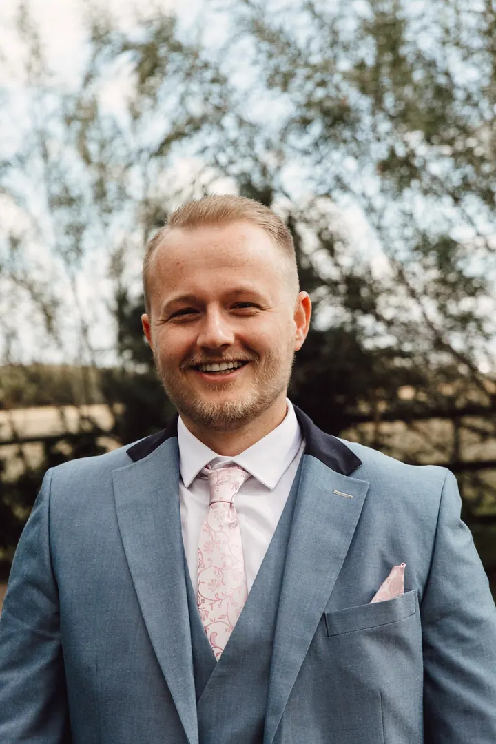 Ryan smiling in his light blue three-piece suit