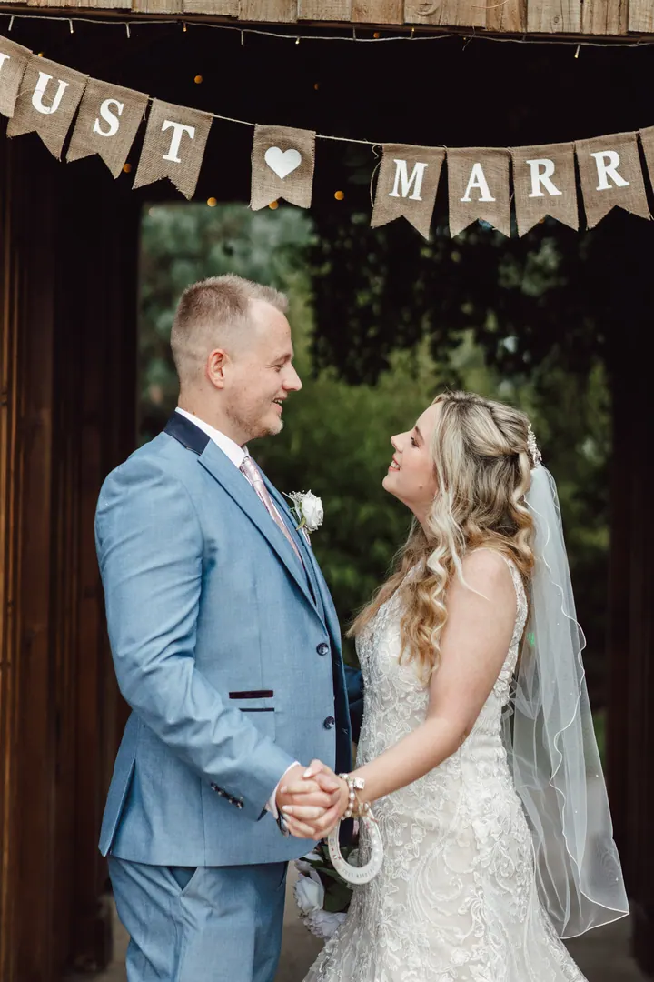 Natasha and Ryan under Just Married bunting in the wooden gateway