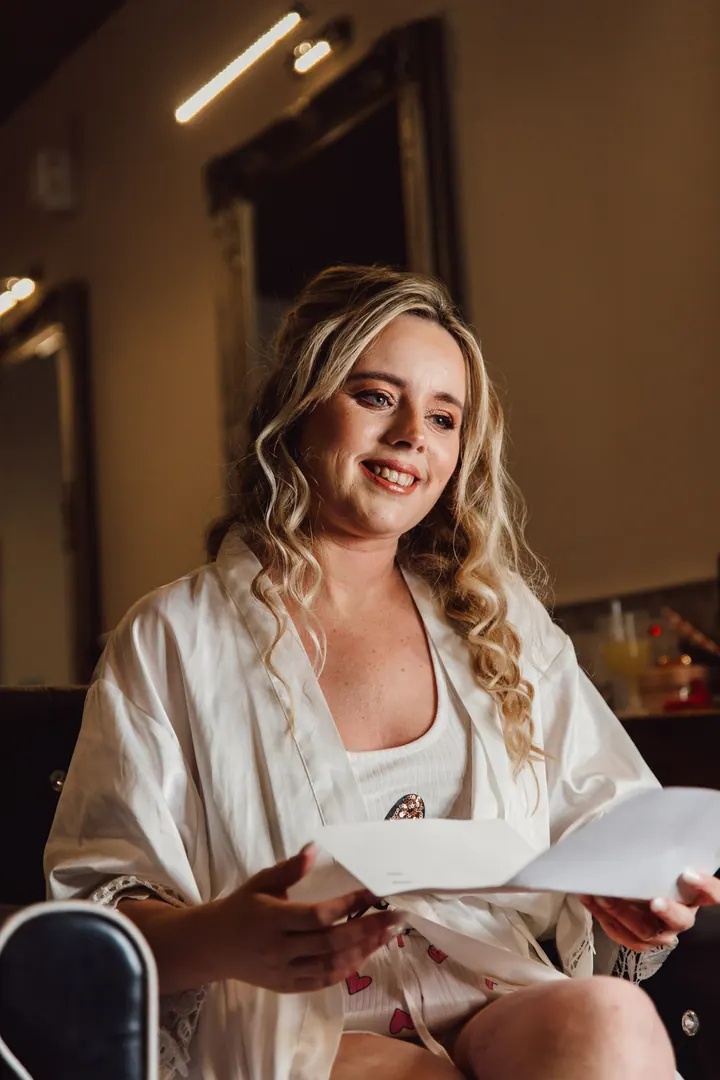 Natasha smiling as she reads a letter from Ryan before the ceremony