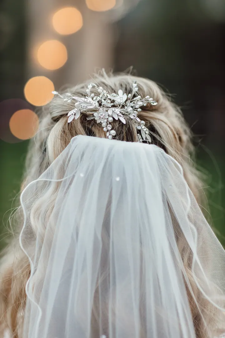 The back of Natasha&rsquo;s veil and hairpiece against fairy lights