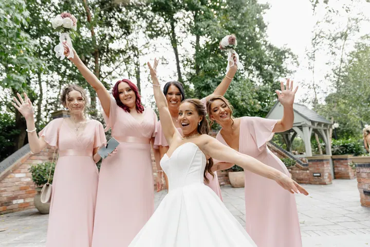 Hayley and her bridesmaids cheering with arms in the air
