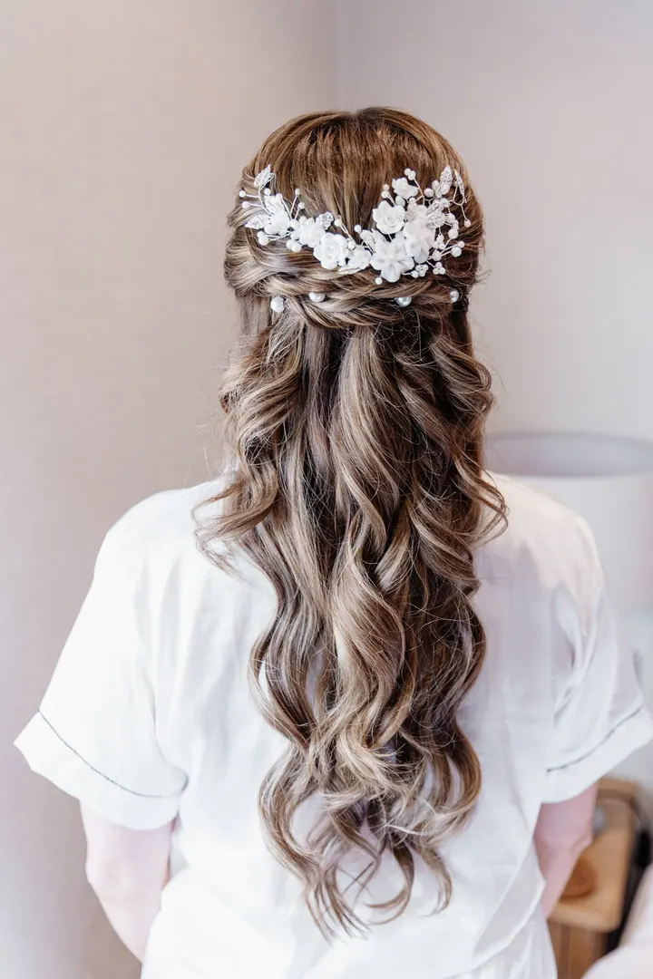 A floral bridal hair piece in long curled hair
