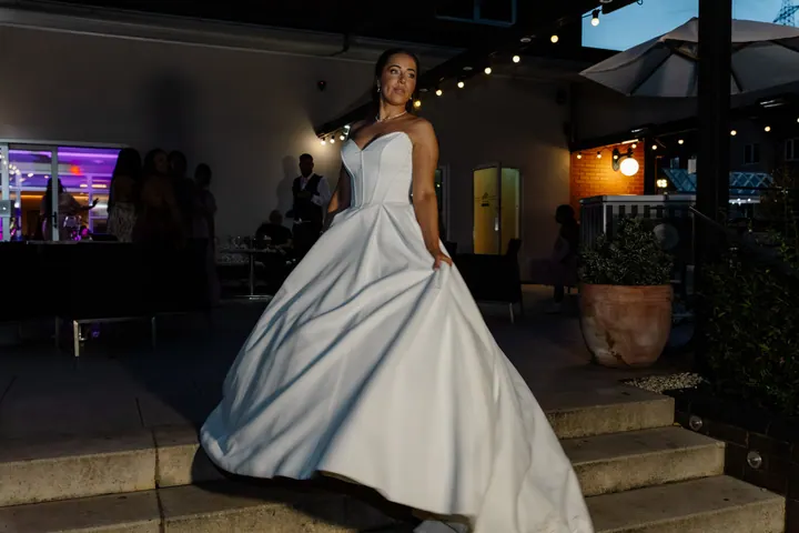 Hayley in her ballgown on the terrace under festoon lights