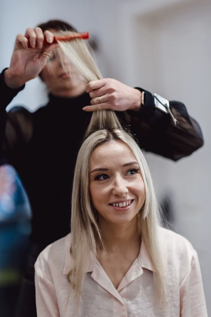 Cicely smiling as her hair is styled on the wedding morning