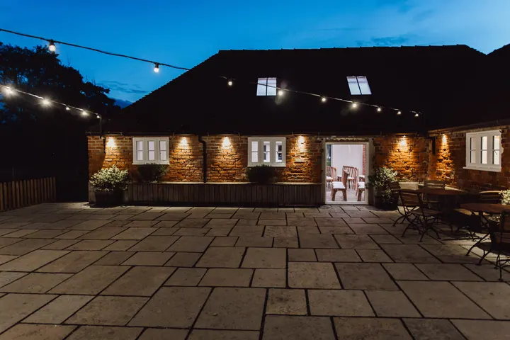 The courtyard at Hanbury Wedding Barn lit up at blue hour