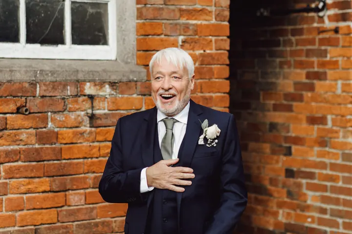 Cicely&rsquo;s dad seeing her in her dress for the first time, hand on his heart