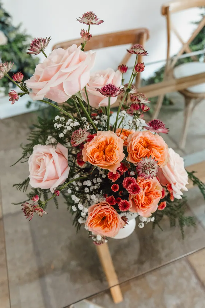 Pedestal arrangement of peach garden roses, astilbe and gypsophila