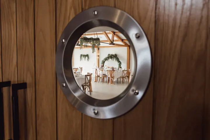 The wedding breakfast room seen through a porthole window in the oak doors