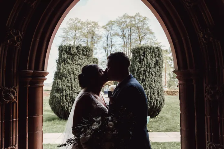 Harry and Hannah kissing in silhouette in a stone archway