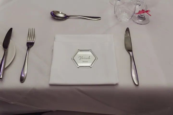 A silver hexagon place name on a white napkin