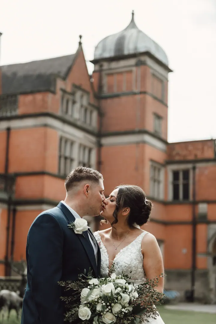 Harry and Hannah kissing beneath the domed tower of Hoar Cross Hall
