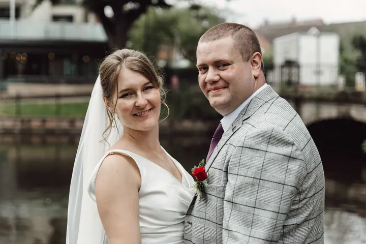 The couple smiling by the water