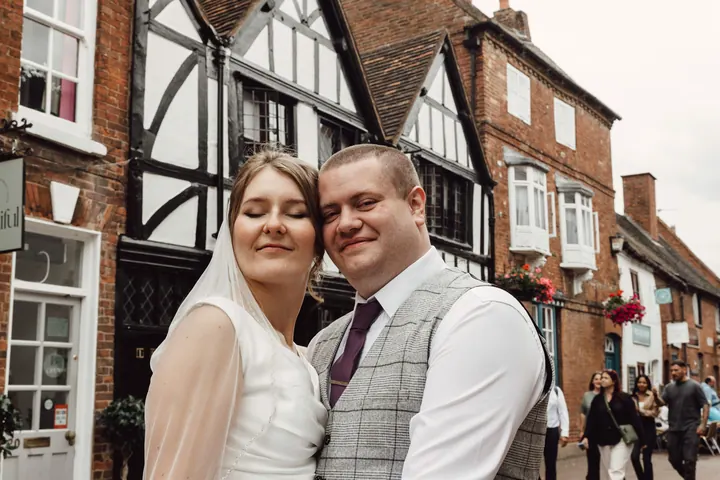 Aleks and Jamie in front of black and white timber-framed buildings