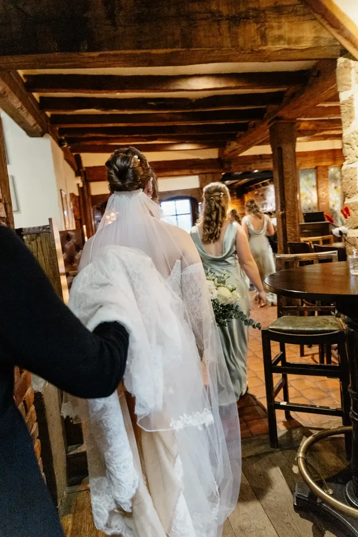 Sam on her way to the ceremony through the old beamed bar