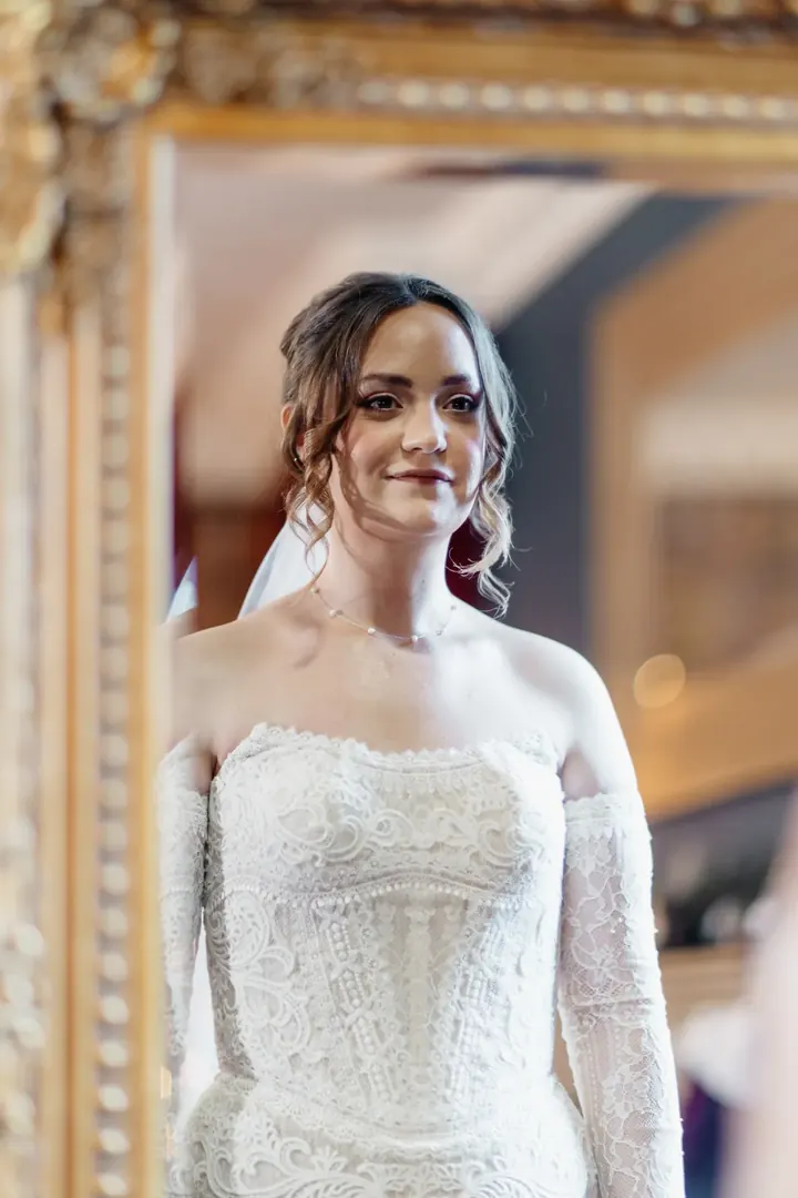 Sam in her wedding dress, reflected in a gold mirror