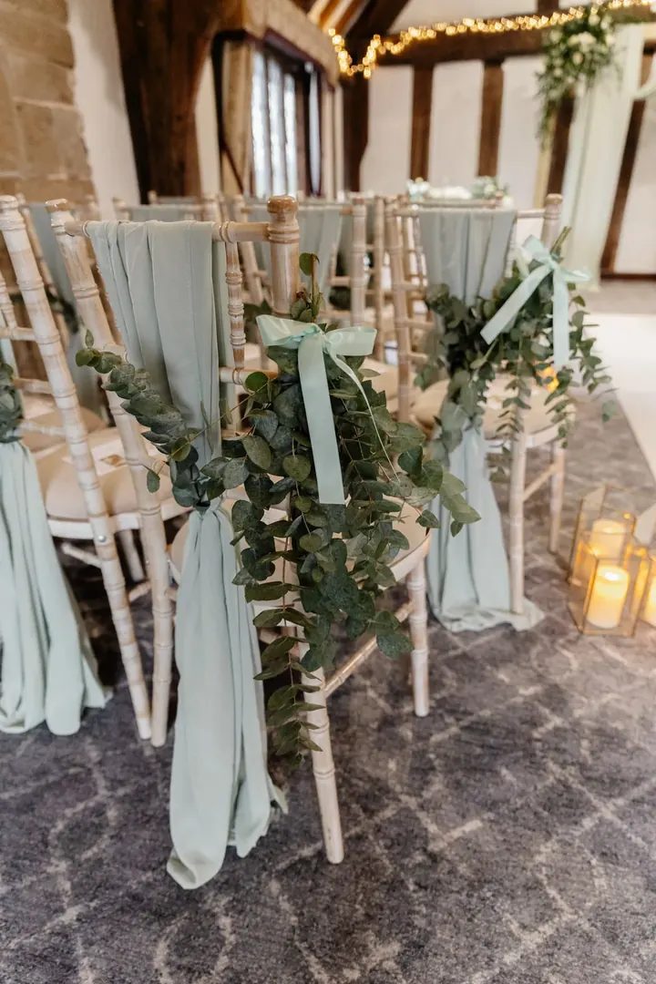 Sage chiffon and eucalyptus tied to the aisle chairs