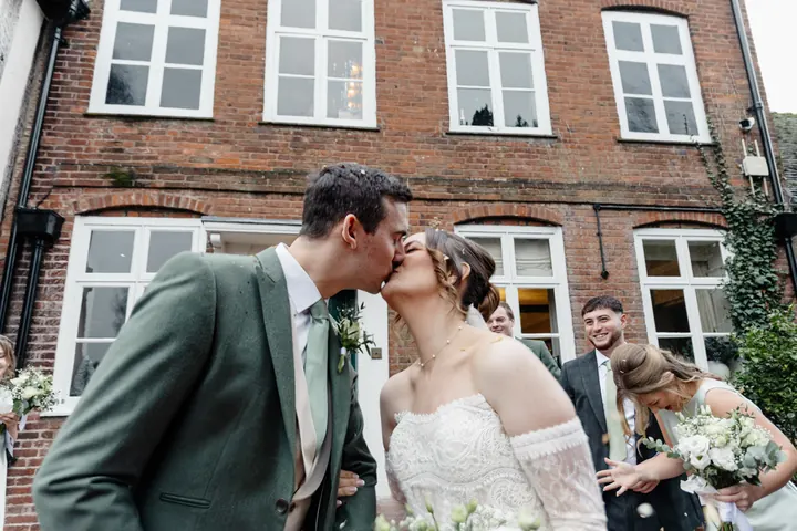 A kiss in a shower of confetti outside The Moat House