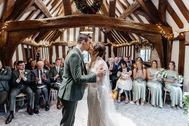 The first kiss as their guests applaud