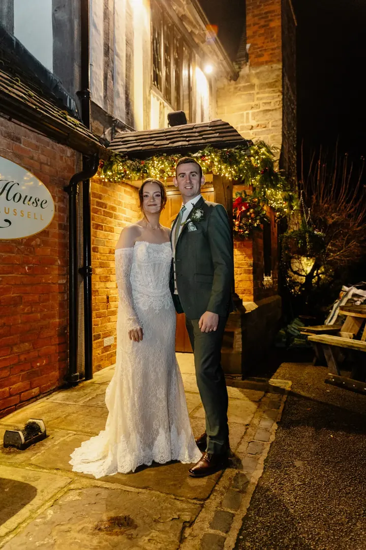Sam and Andrew by the lit-up entrance at night