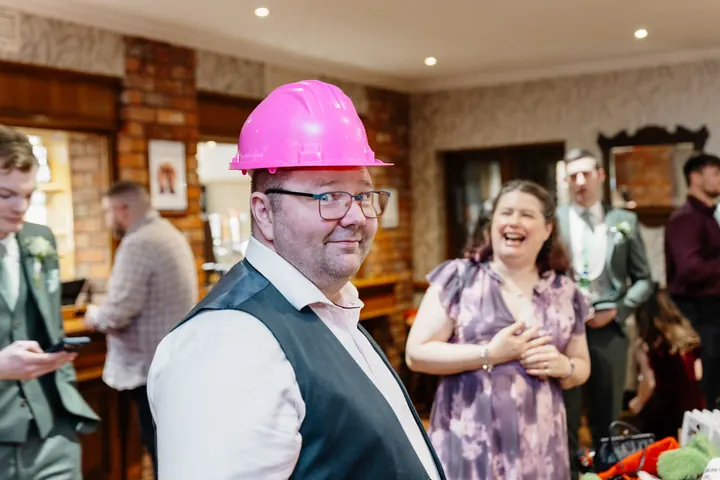 A guest in a pink hard hat making everyone laugh