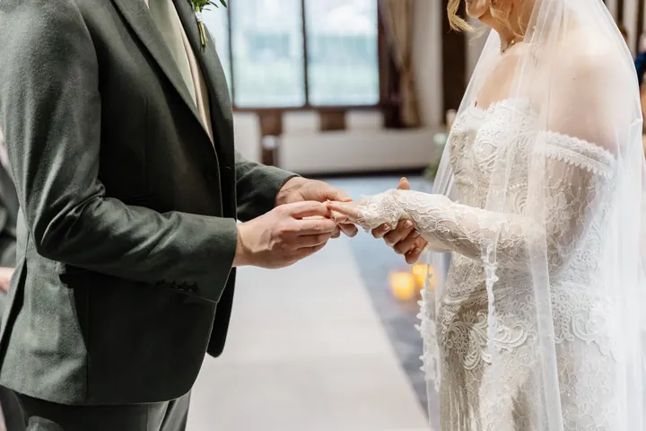 Andrew placing the ring on Sam&rsquo;s finger