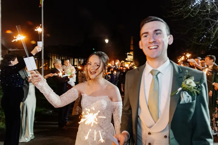Sam laughing with a sparkler as Andrew grins