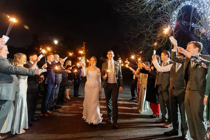 Guests holding sparklers in a tunnel along the drive
