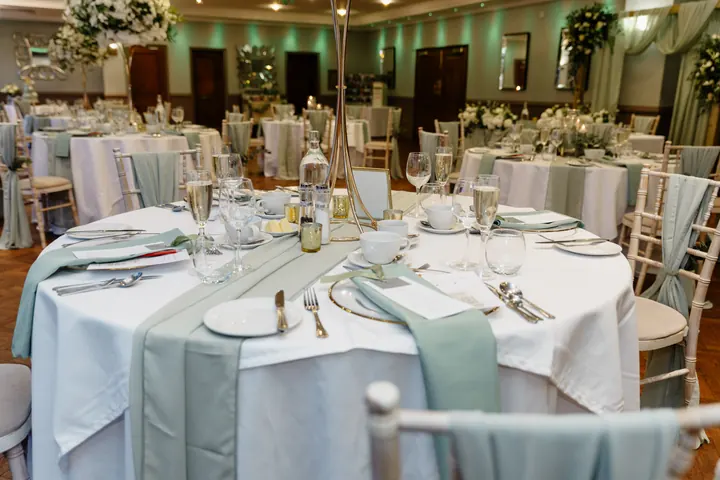 Reception tables set with sage runners and white flowers