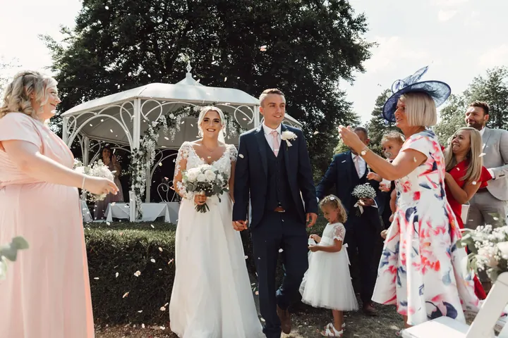 Confetti thrown as the newlyweds walk back up the aisle